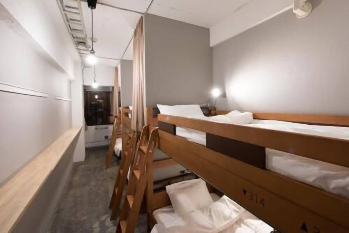 Un dormitorio con literas, un escritorio y una silla.