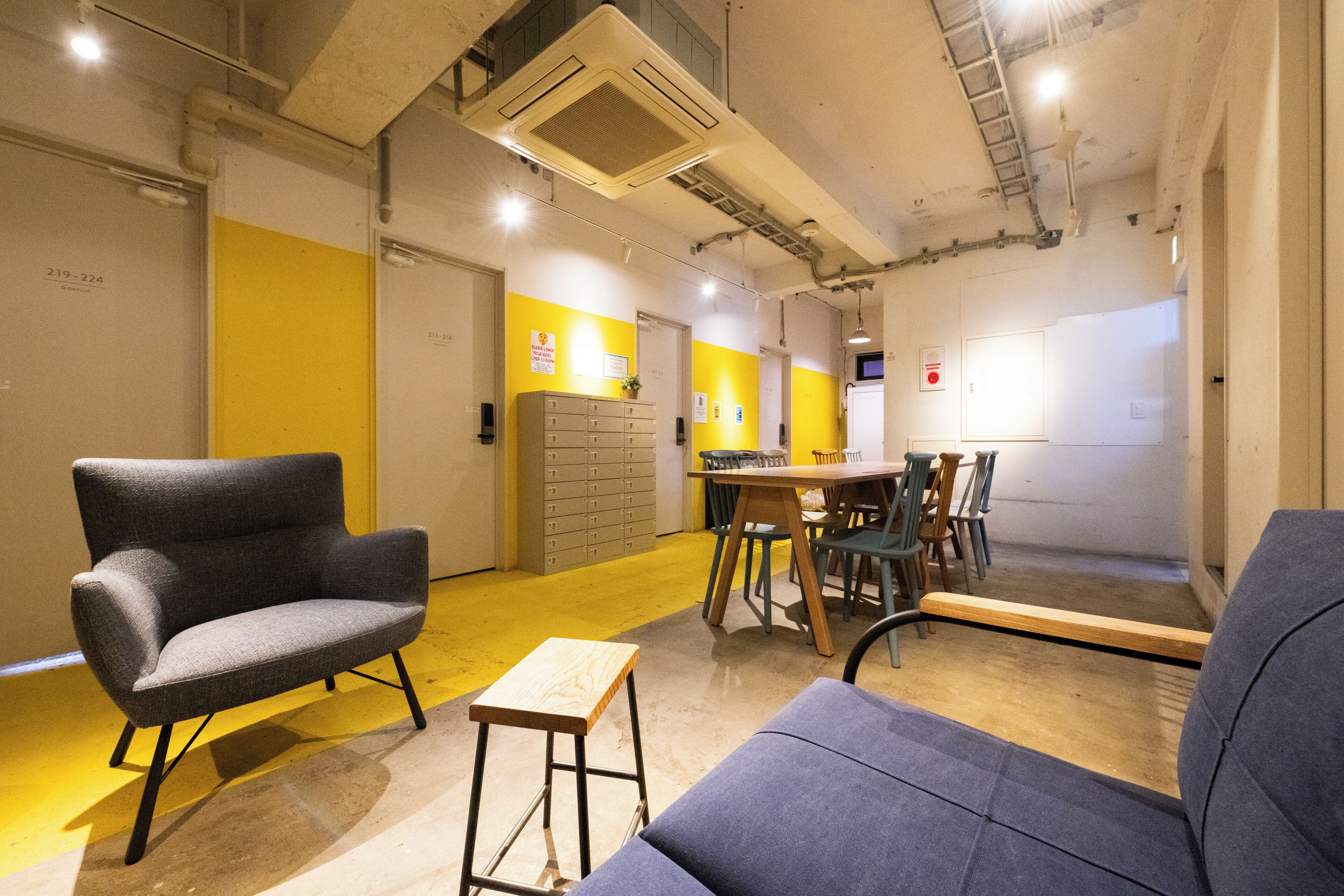 A modern interior with a seating area, a small table, and a kitchenette.