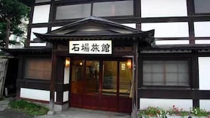 A traditional Japanese building with a sign reading "石場旅館".