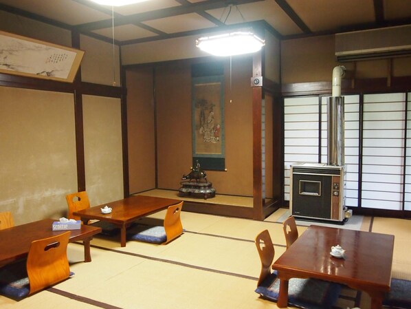 A traditional Japanese room with tatami flooring, wooden furniture, a shoji screen, and a modern air conditioning unit. - Ishiba Ryokan (Hirosaki)