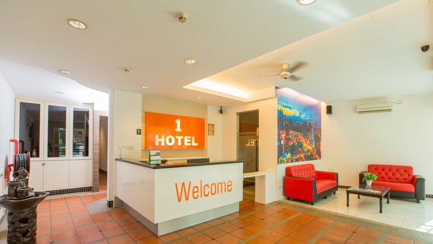 A hotel reception area with a '1 HOTEL Welcome' sign, a reception desk, a red sofa, and a tiled floor. - 1 Hotel Pudu Cheras (Kuala Lumpur)