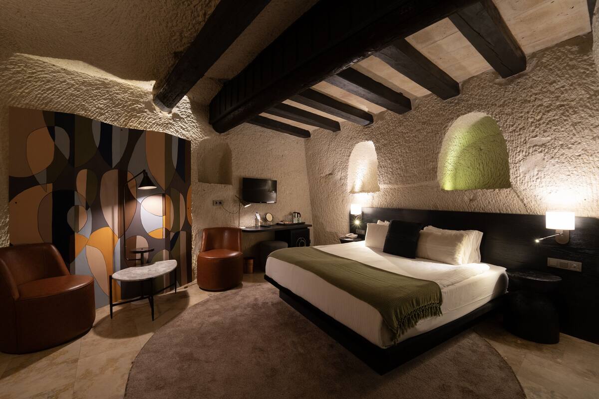 Una camera da letto con un letto grande, una scrivania, una sedia e un tavolino.