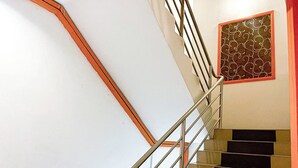 Una escalera con barandales de metal y un muro con diseño.