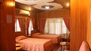 A room with two beds, a small round table, and a sofa. - Kaung Lay Inn (Yangon)