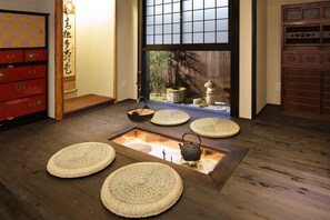 Ein traditioneller japanischer Raum mit Tatami-Böden, Shoji-Schirm und einer Tatami-Matte in der Mitte.