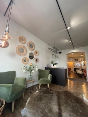 Un salon moderne avec un canapé, des fauteuils, une table basse et un tapis à longues mèches.
