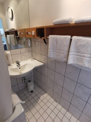 Une salle de bain équipée d’un lavabo, d’un miroir, d’un porte-serviettes et de toilettes.