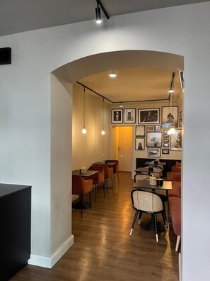 Un intérieur moderne comprenant un coin repas, un plancher en bois et des luminaires suspendus.