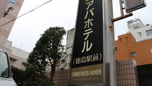 Hotellin kyltti, jossa on japaninkielisiä merkkejä ja puhelinnumero.