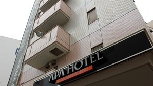 Rakennuksessa on kyltti, jossa lukee ”APA HOTEL”, ja pienempi kyltti, jossa lukee ”TOKUSHIMA-EKIMAE”.