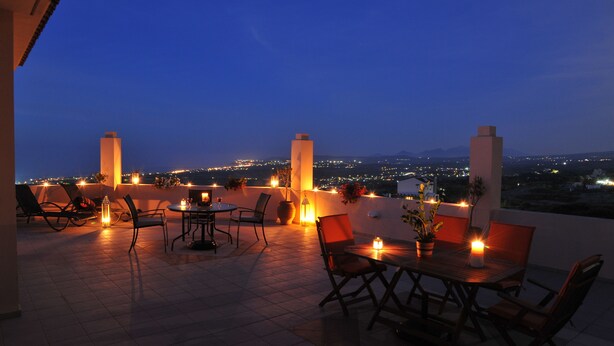 An outdoor terrace with a dining area, chairs, and candles. - Diogenis Home (Rethymno)