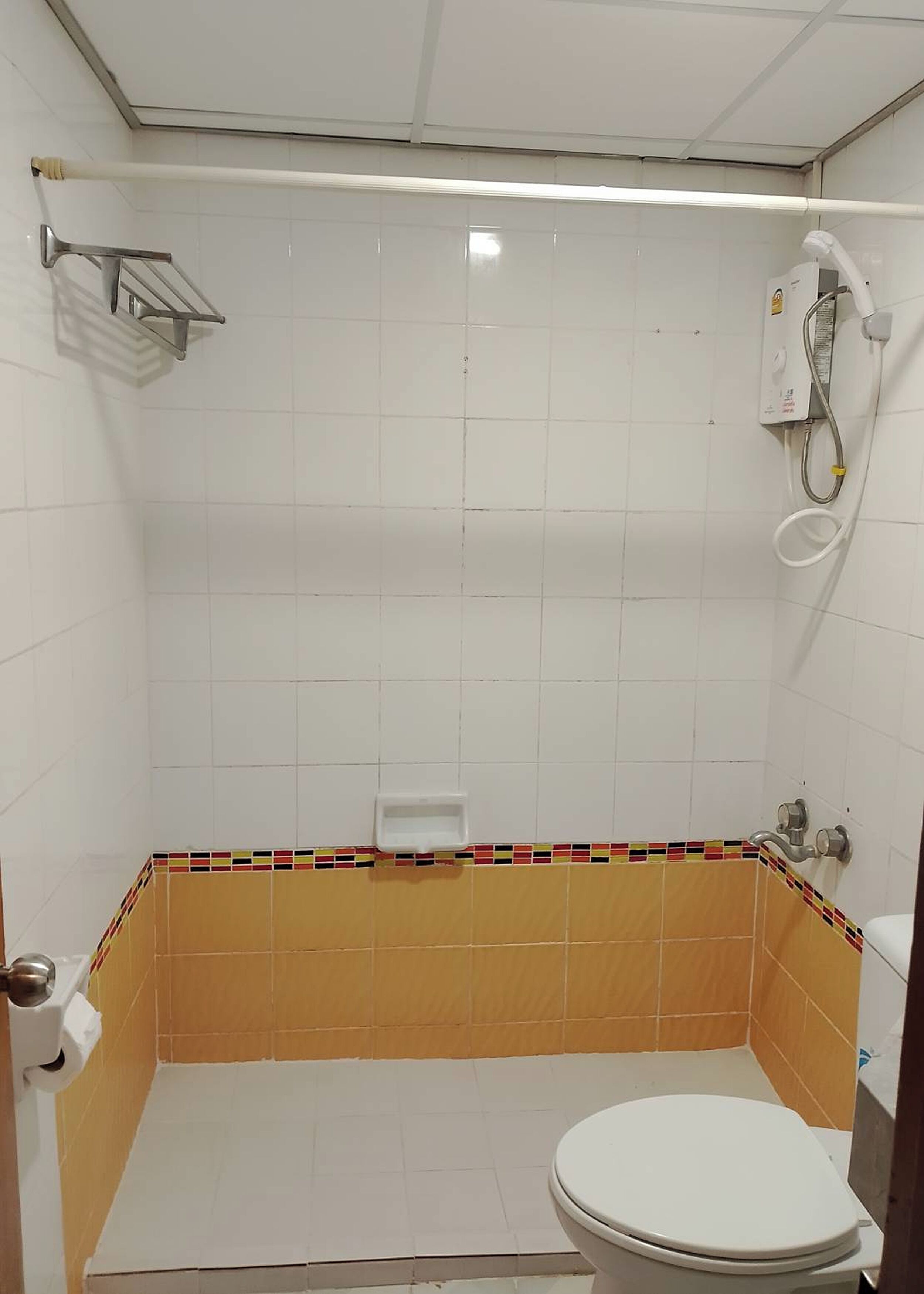 Une petite salle de bain avec des toilettes, une douche et un lavabo.