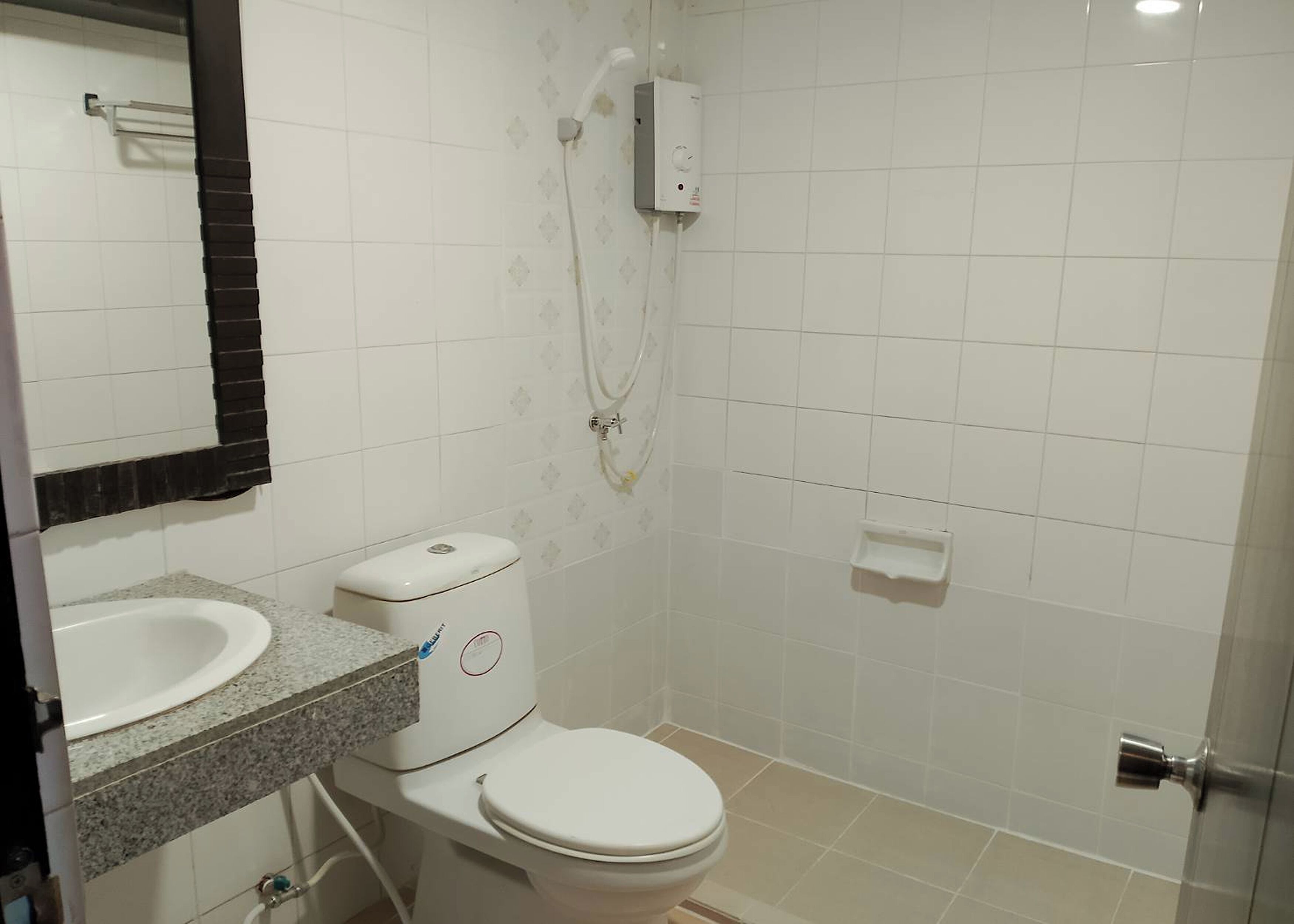 A bathroom with a toilet, sink, and shower.