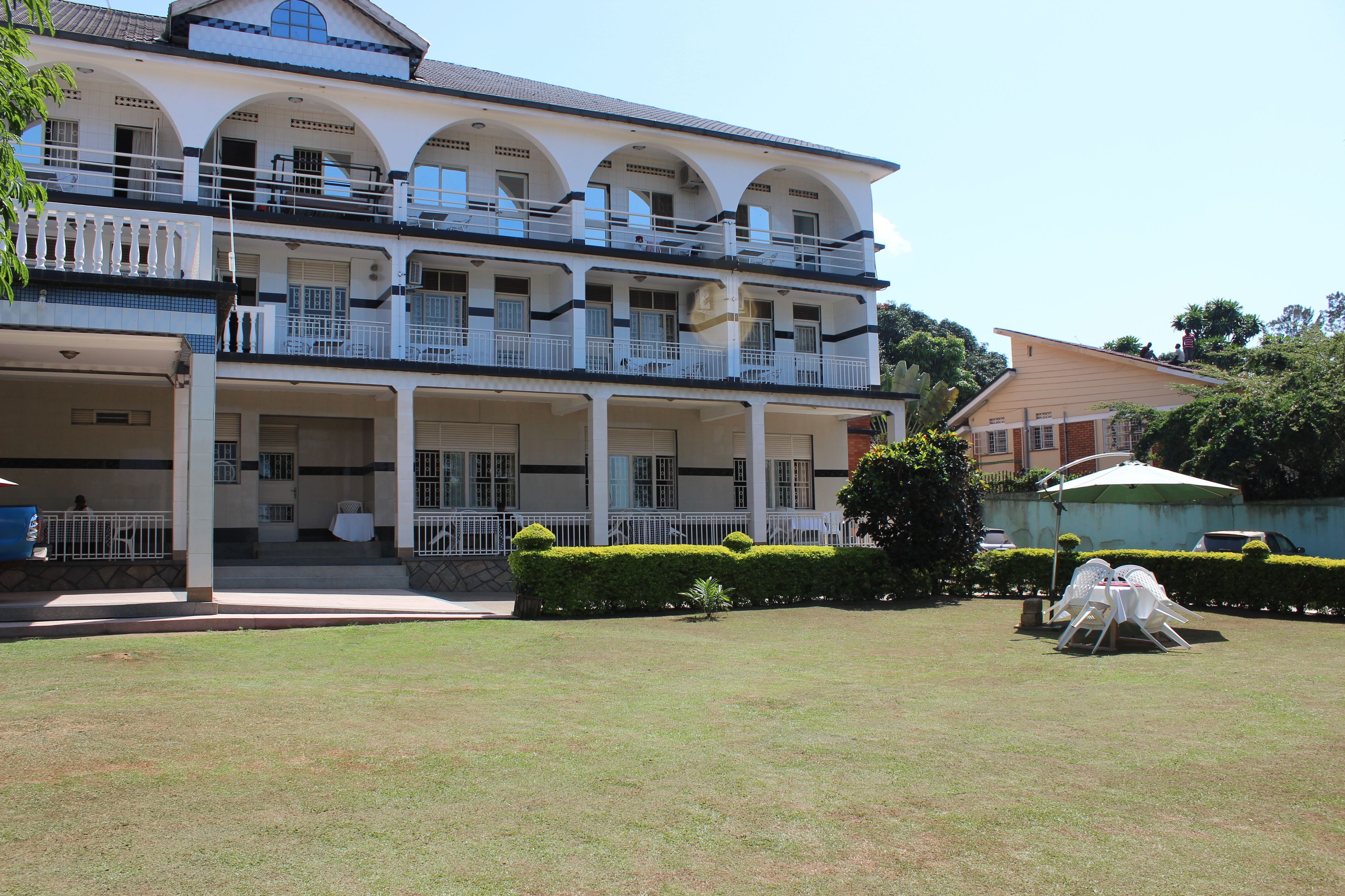Un edificio de dos pisos con balcones y un patio cubierto.