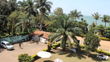 A hotel with a beach view, palm trees, and outdoor seating.