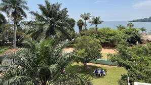 Un jardín tropical con palmeras y vista al mar.