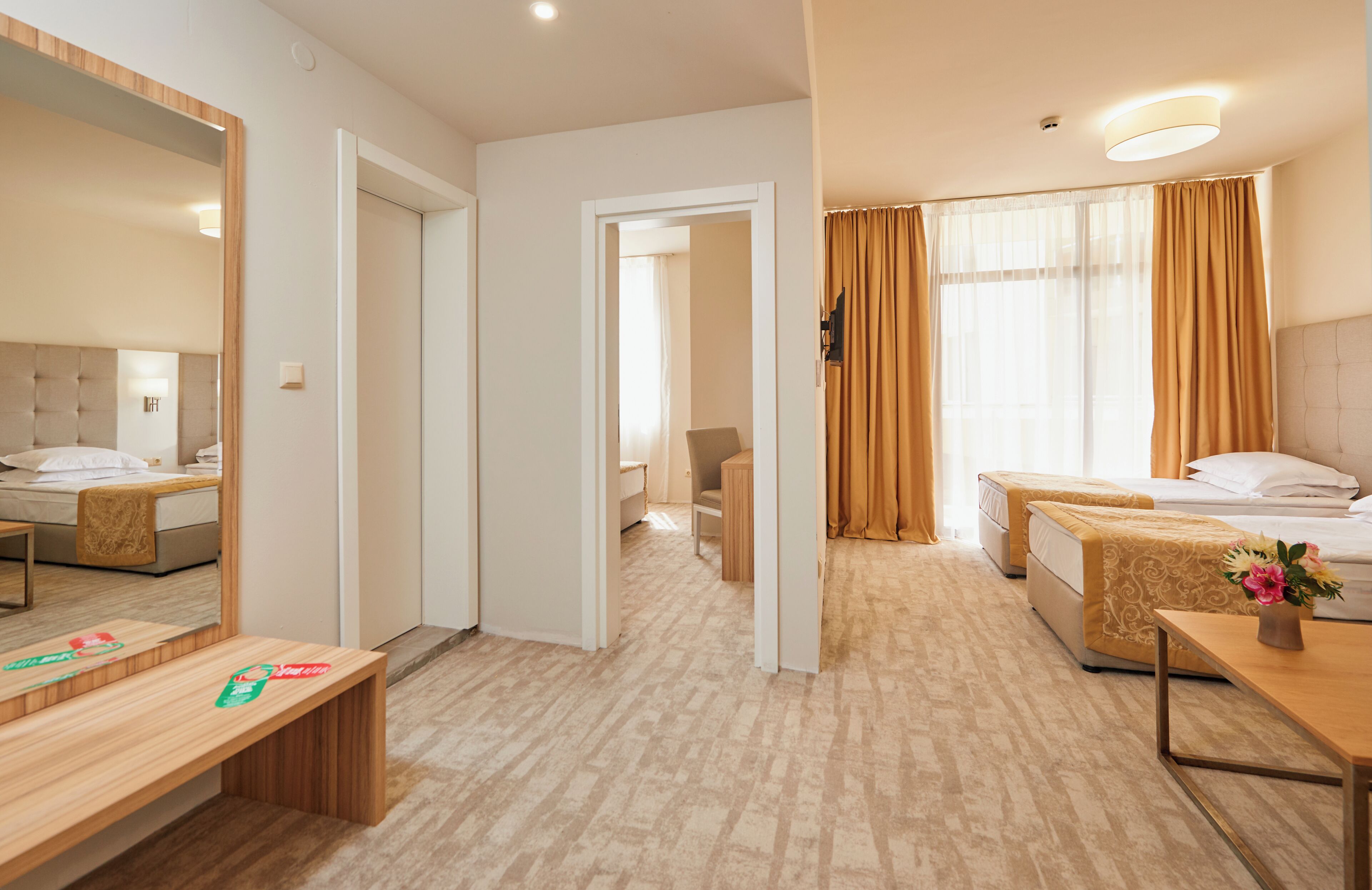 Una habitación de hotel con cama, mesita de noche, silla y espejo.