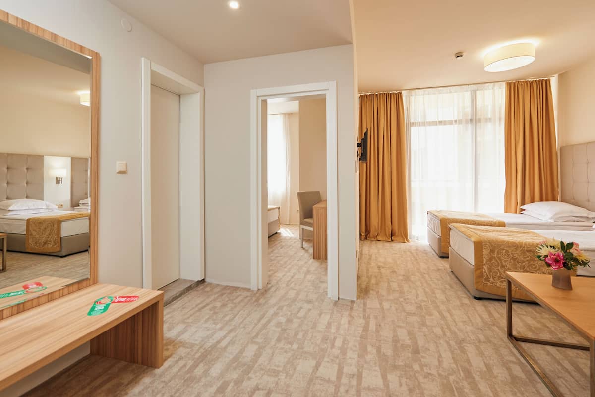 Une chambre d’hôtel avec un lit, une table de chevet, une chaise et un miroir.