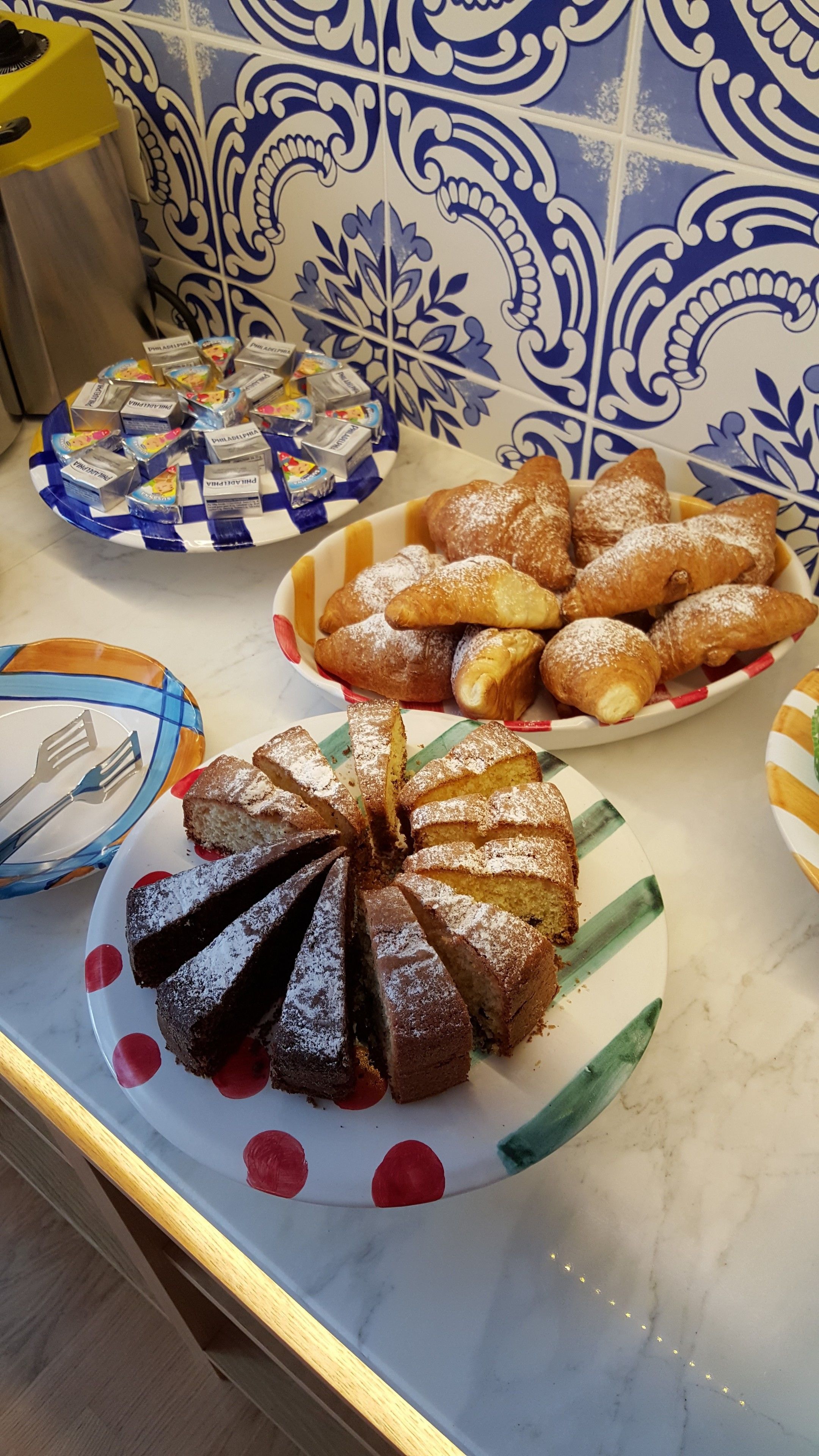 A buffet table with various desserts including a chocolate cake, pastries, and a fruit salad.