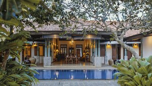 A poolside area with a covered seating area, a swimming pool, and surrounding greenery. - Villa Republic River View Bentota (Aluthgama)