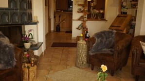 A cozy living room with leather sofas, a coffee table, and a rustic wooden floor.