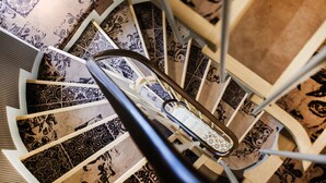 A spiral staircase with ornate black and white patterned tiles. - Hôtel Le Mireille (Paris)
