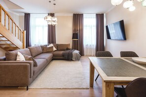 Departamento superior, 2 habitaciones | Área de sala de estar | Televisión de pantalla plana 