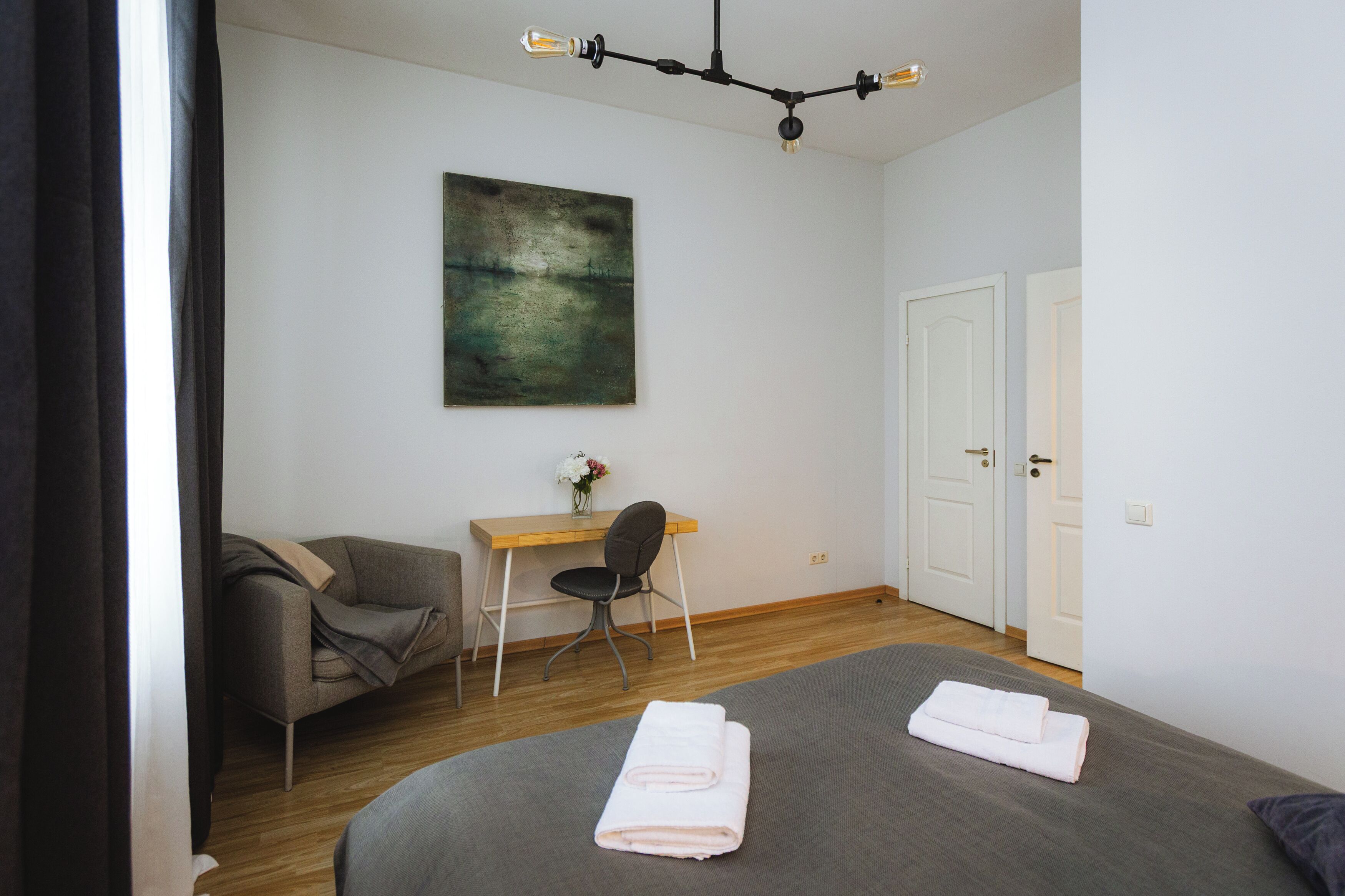 A modern bedroom with a bed, a desk, and a chair.