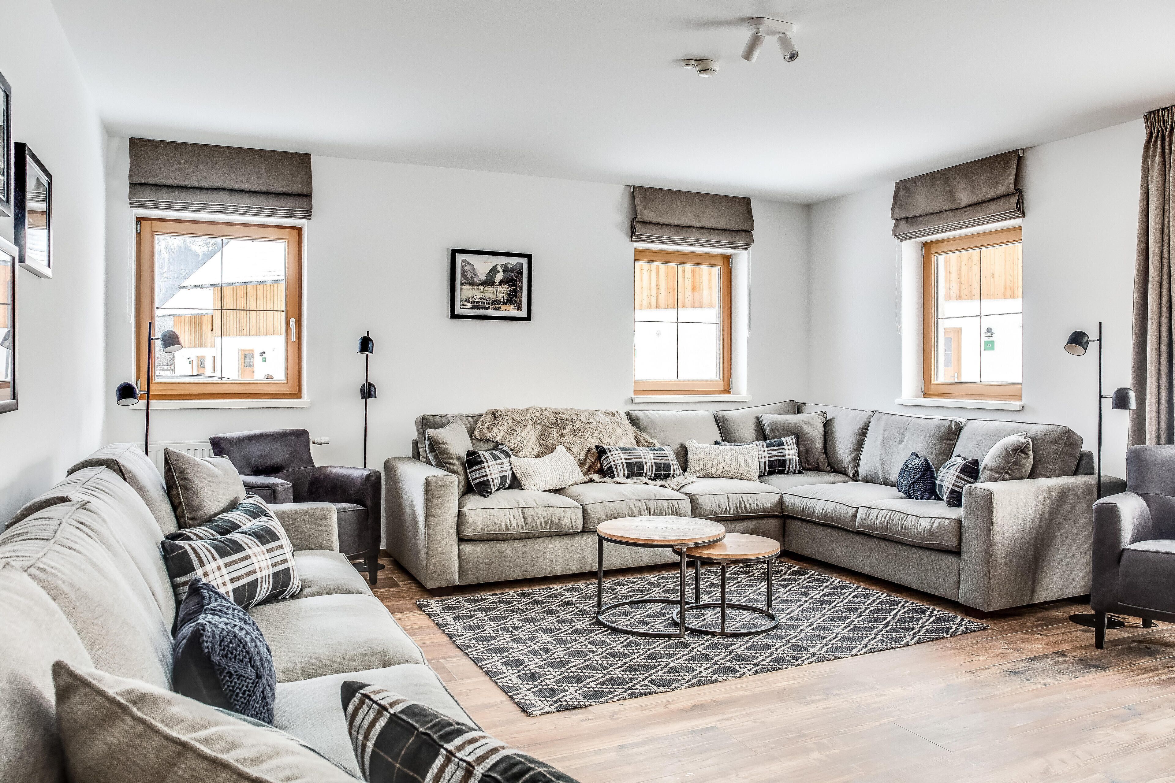 A modern living room with a sectional sofa, a round coffee table, and a patterned rug.