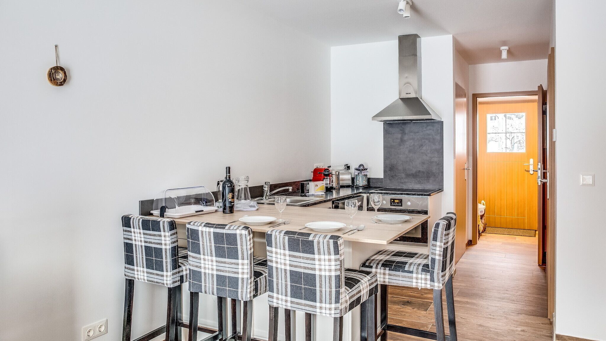 A modern kitchen with a central island, stainless steel appliances, and a large window.