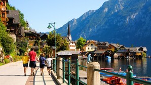 A pedestrian bridge with a view of a lake and mountains. - Dormio Resort Obertraun (Obertraun)