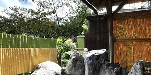 A traditional Japanese garden with bamboo fences, stone lanterns, and a wooden structure. - Hotel Ohruri Nasu Shiobara (Nasushiobara)
