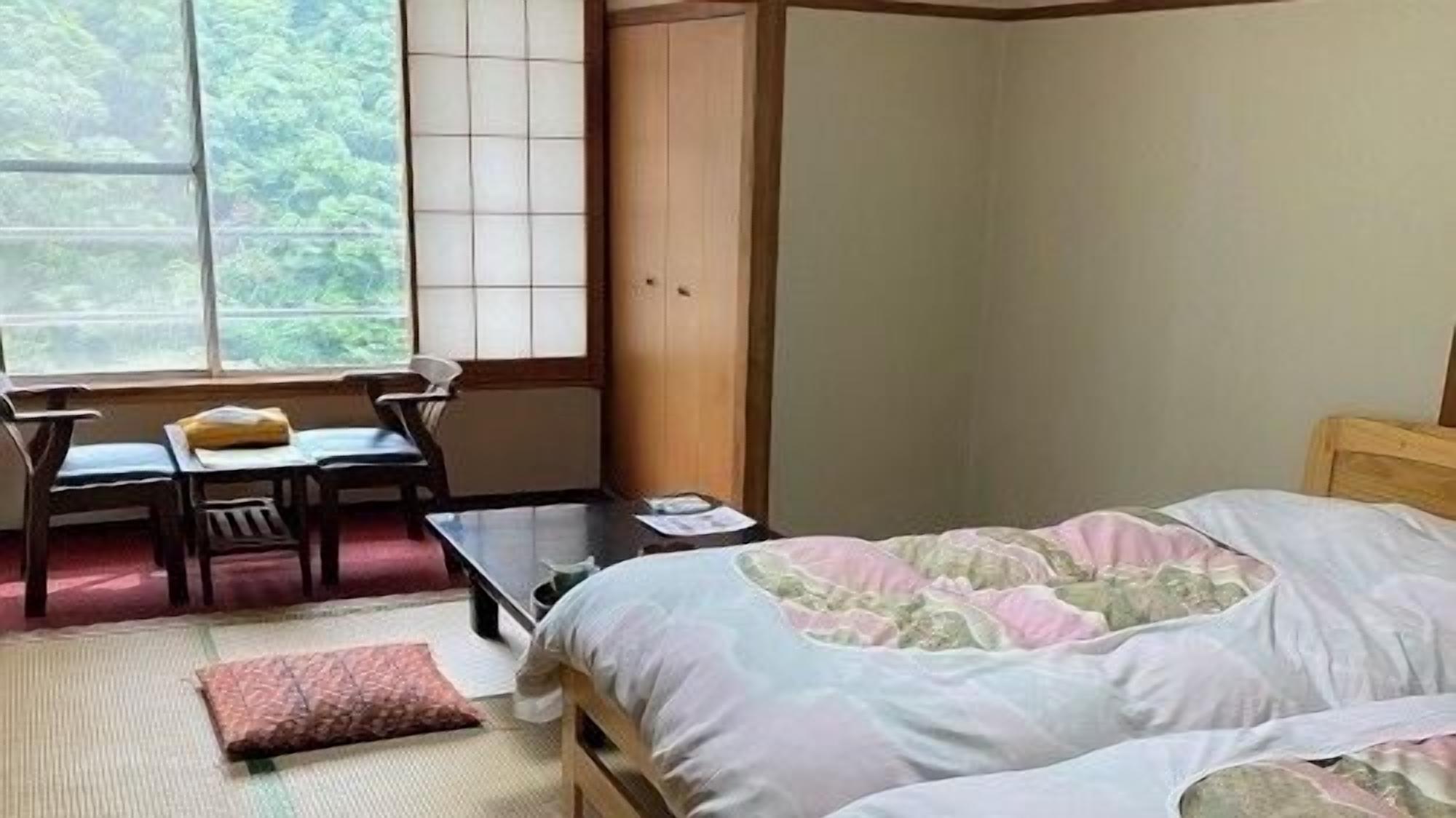 A bedroom with a bed, a desk, and a chair.