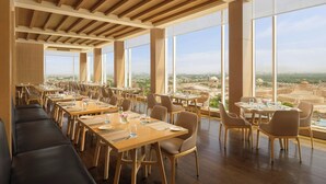 A spacious dining area with high ceilings and large windows offering a city view. - Renaissance Lucknow Hotel (Lucknow)