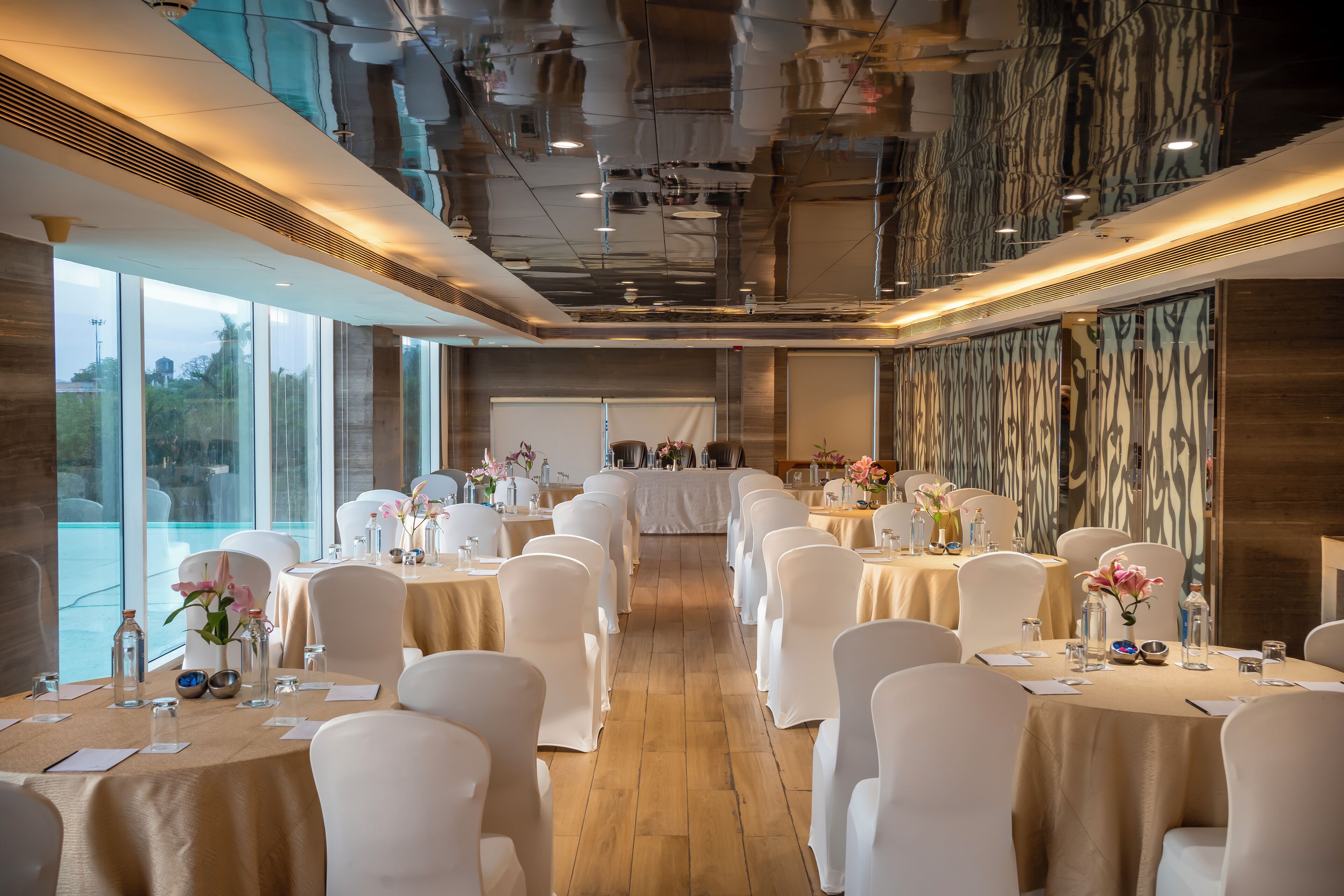 A conference room with tables set for a meeting, large windows, and a modern interior design.
