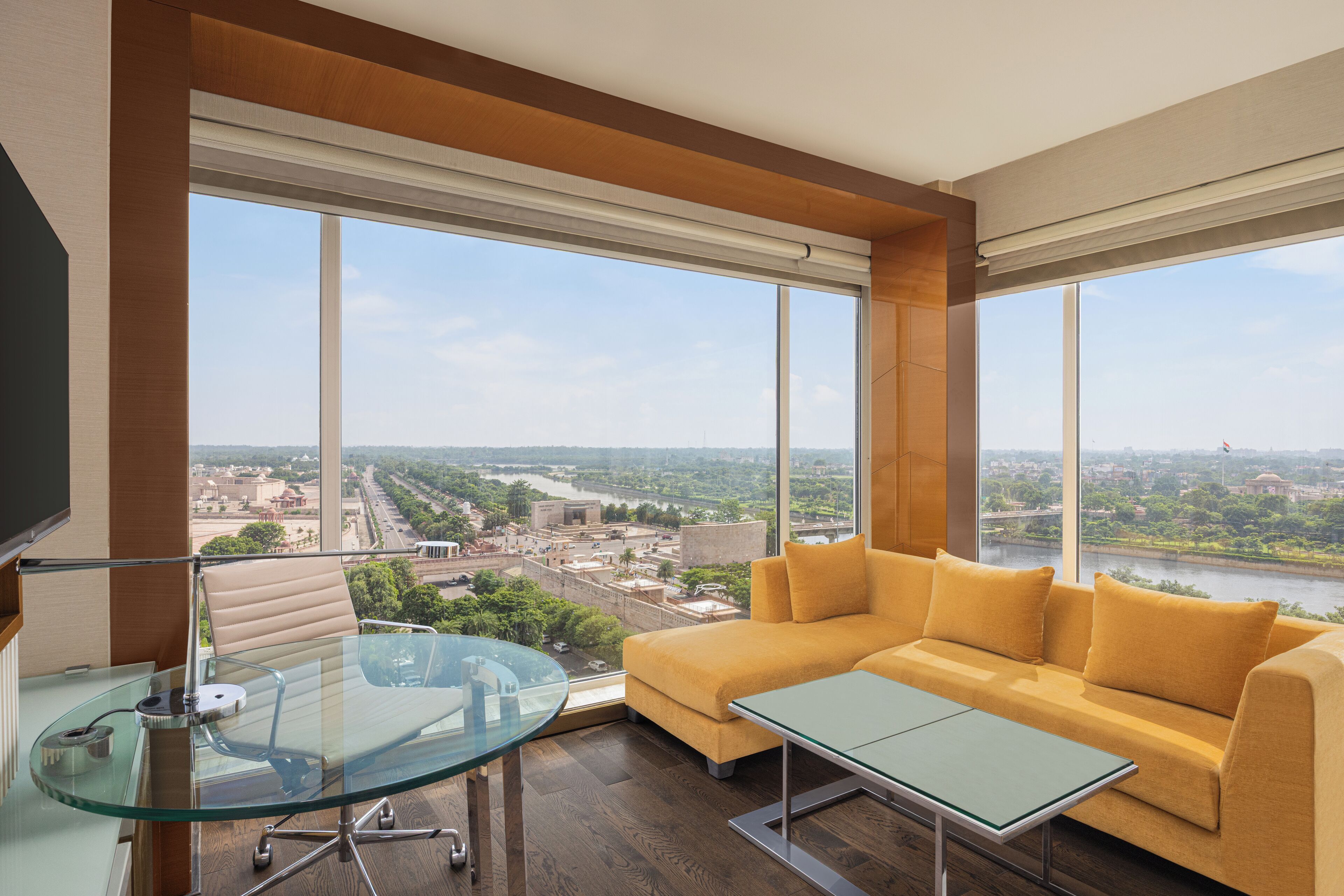 Una sala moderna con una mesa de vidrio, un sofá y ventanas amplias con vista a la ciudad.