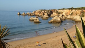 Una playa con formaciones rocosas y agua azul cristalina.