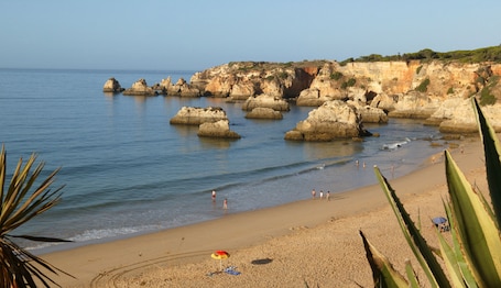 Una playa cerca, arena blanca, sillas reclinables de playa, sombrillas