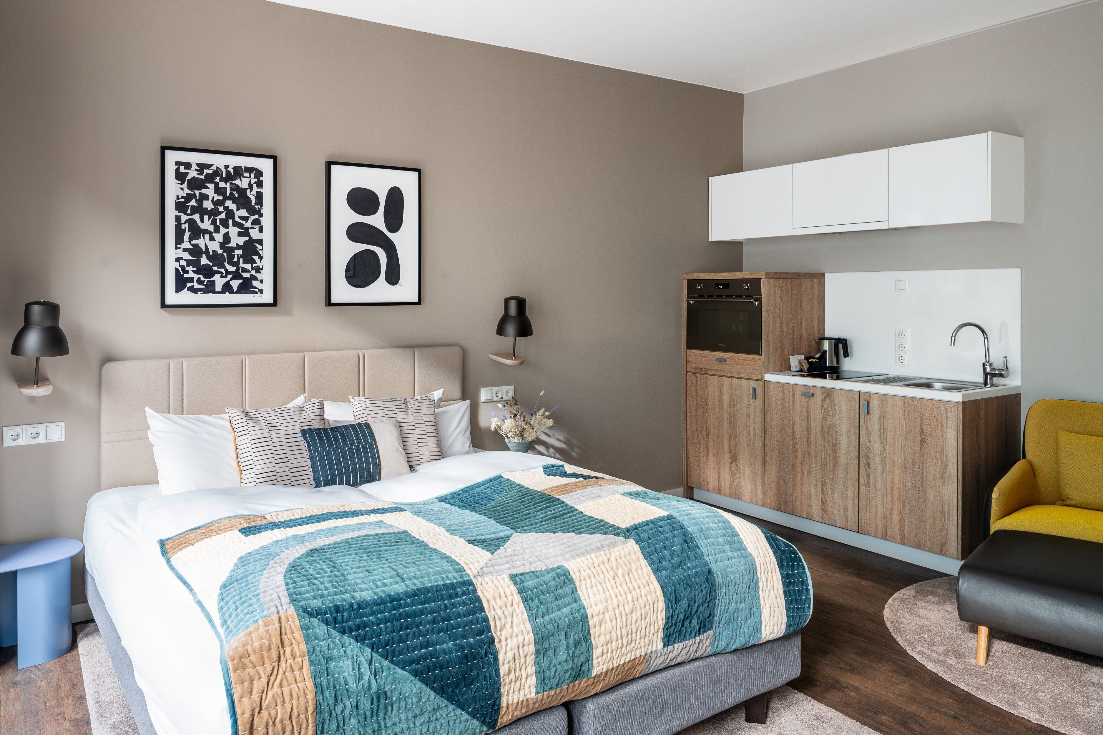 Un dormitorio moderno con una cama grande, una mesita de noche, un armario empotrado y un televisor montado en la pared.