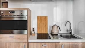 Una cucina moderna con elettrodomestici in acciaio inossidabile, mobili in legno e piano cottura integrato.