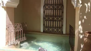 Een buitenzwembad, parasols voor strand/zwembad