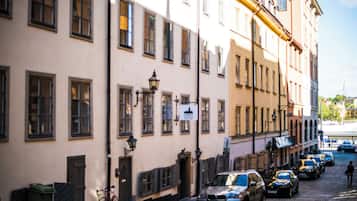 Une rue pavée bordée de bâtiments historiques, de voitures garées et d’un vélo.