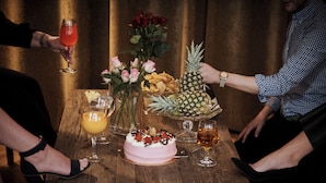 A wooden table with a cake, drinks, and snacks. - Castle House Inn (Stockholm)