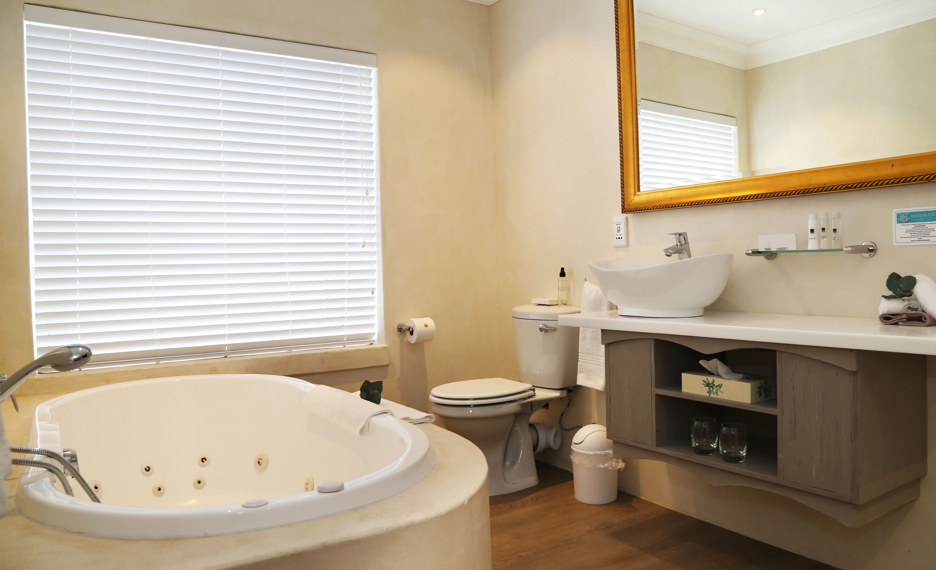A bathroom with a bathtub, toilet, sink, and a mirror.