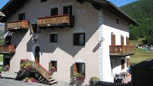 A two-story building with balconies, a staircase, and flower boxes. - Residence Gardenia (Livigno)