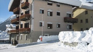 A multi-story building with balconies, a sign reading "Resort", and snow-covered surroundings. - Residence Gardenia (Livigno)
