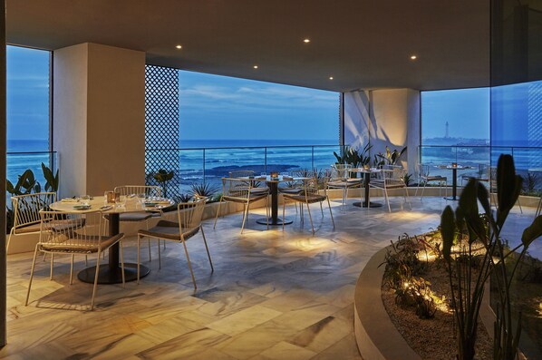 An outdoor dining area with tables and chairs, overlooking the ocean. - Four Seasons Hotel Casablanca (Casablanca)