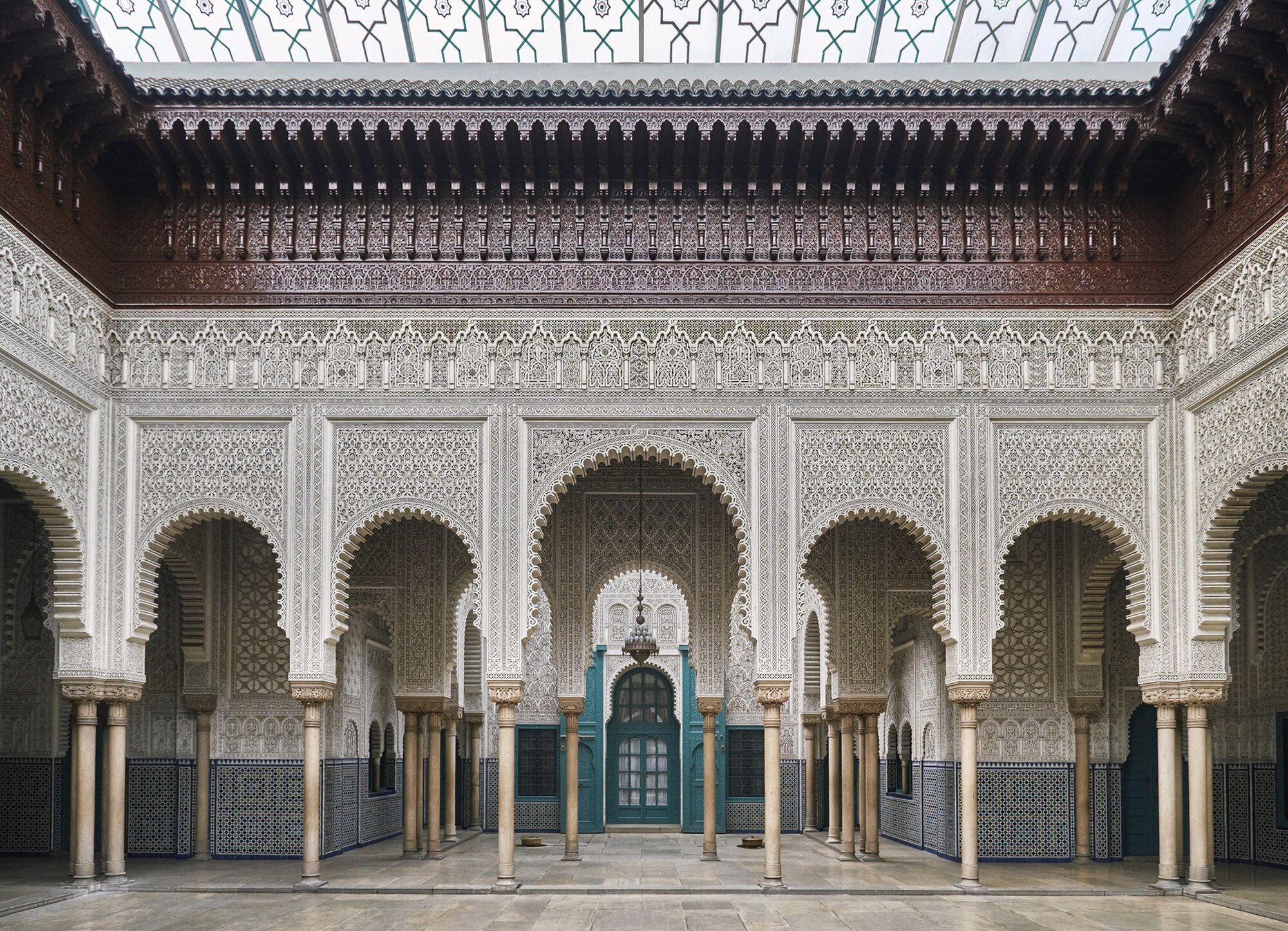 Un cortile decorato con elaborate piastrelle, archi e colonne.