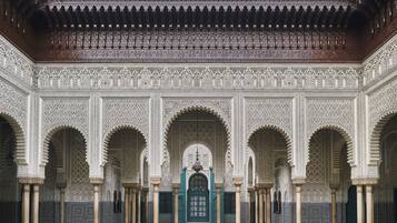 Un cortile decorato con elaborate piastrelle, archi e colonne.