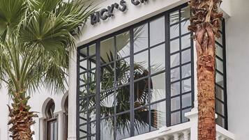 A building with a balcony and palm trees.